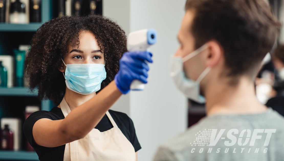 business owner takes temperature of customer