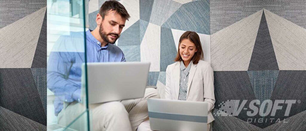 Two coworkers working on laptop in private room they booked with ServiceNow Workplace Reservation.