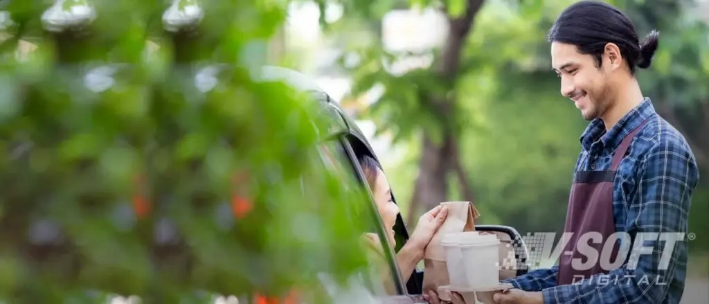 Quick Service Restaurant Worker deliver coffee to customer’s car after receiving mobile notification.